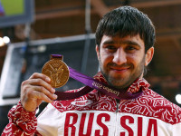 Russia's Mansur Isaev holds his gold medal after beating Japan's Riki Nakaya in the men's -73kg final judo match at the London 2012 Olympic Games